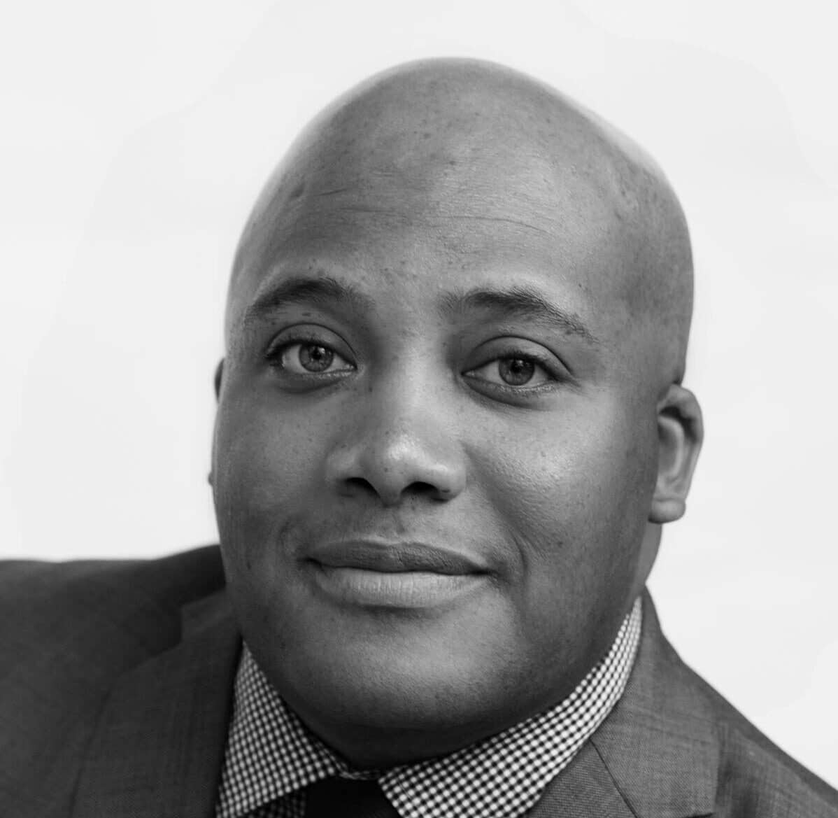 a man wearing a suit and tie smiling at the camera