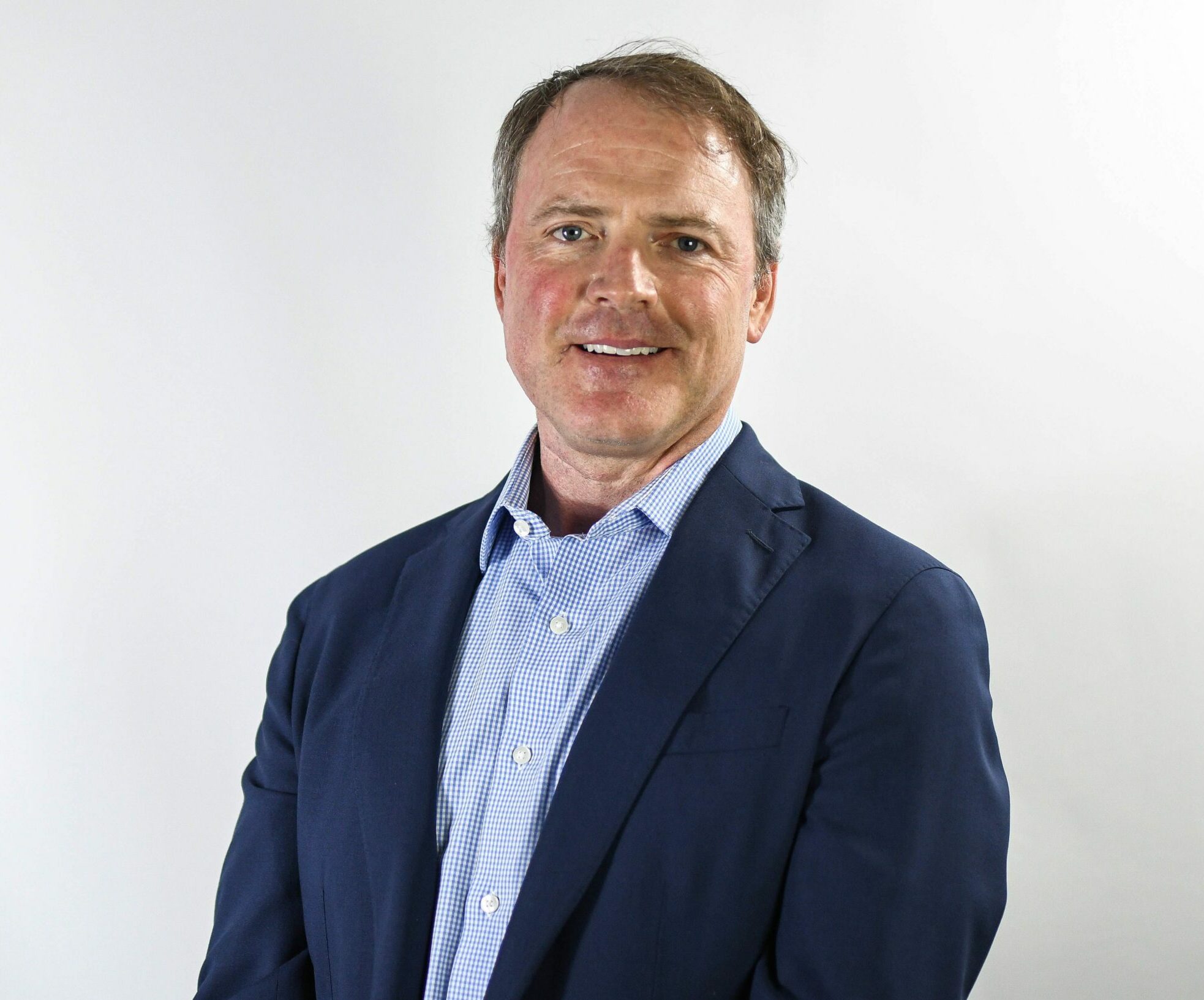 a man wearing a suit and tie smiling at the camera